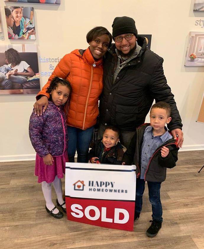 A family of five with a Sold sign