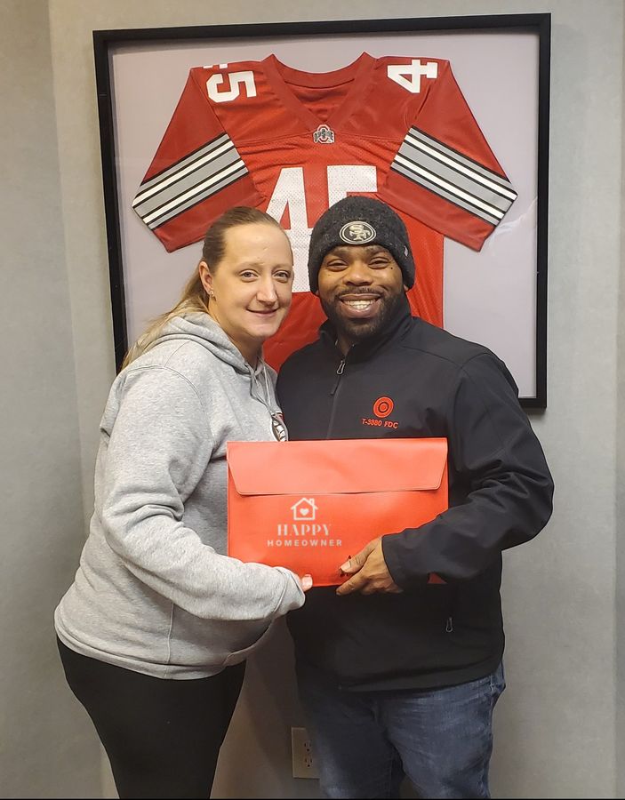 A couple holding their new-home folder