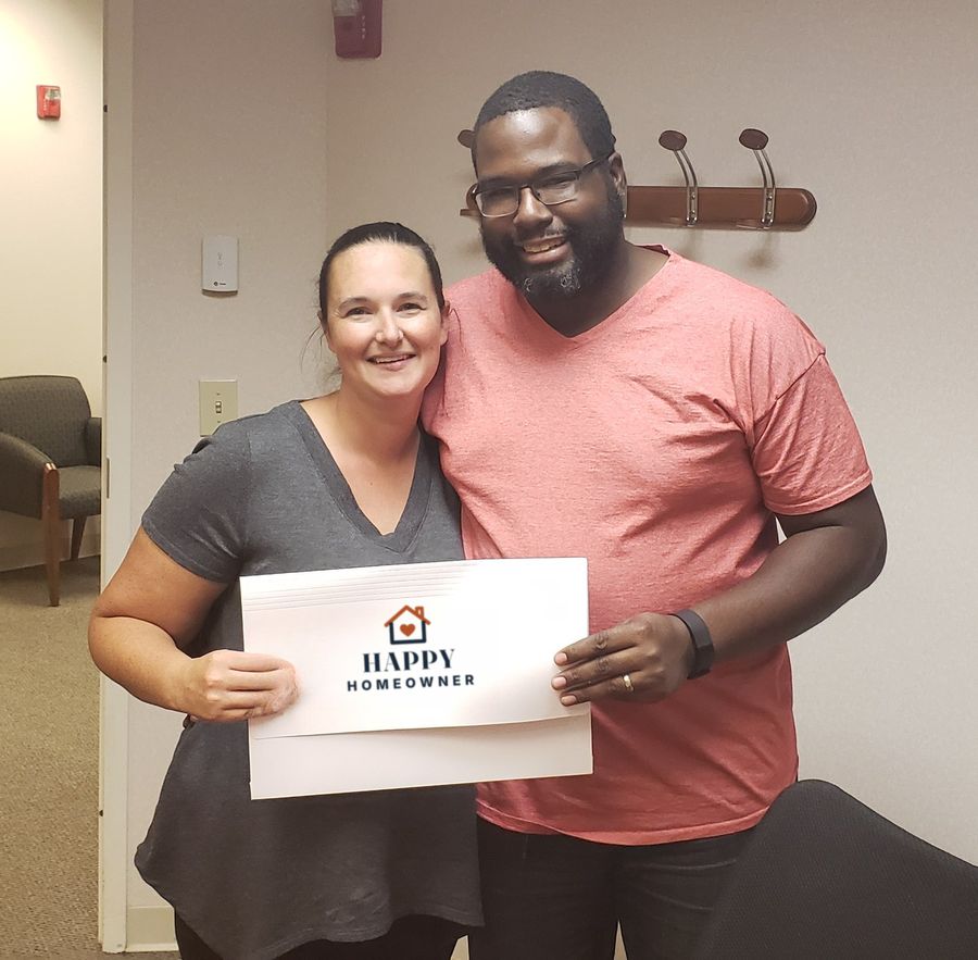 A happy couple holding their closing folder