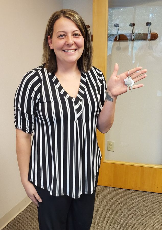 A new homeowner waving her new house key
